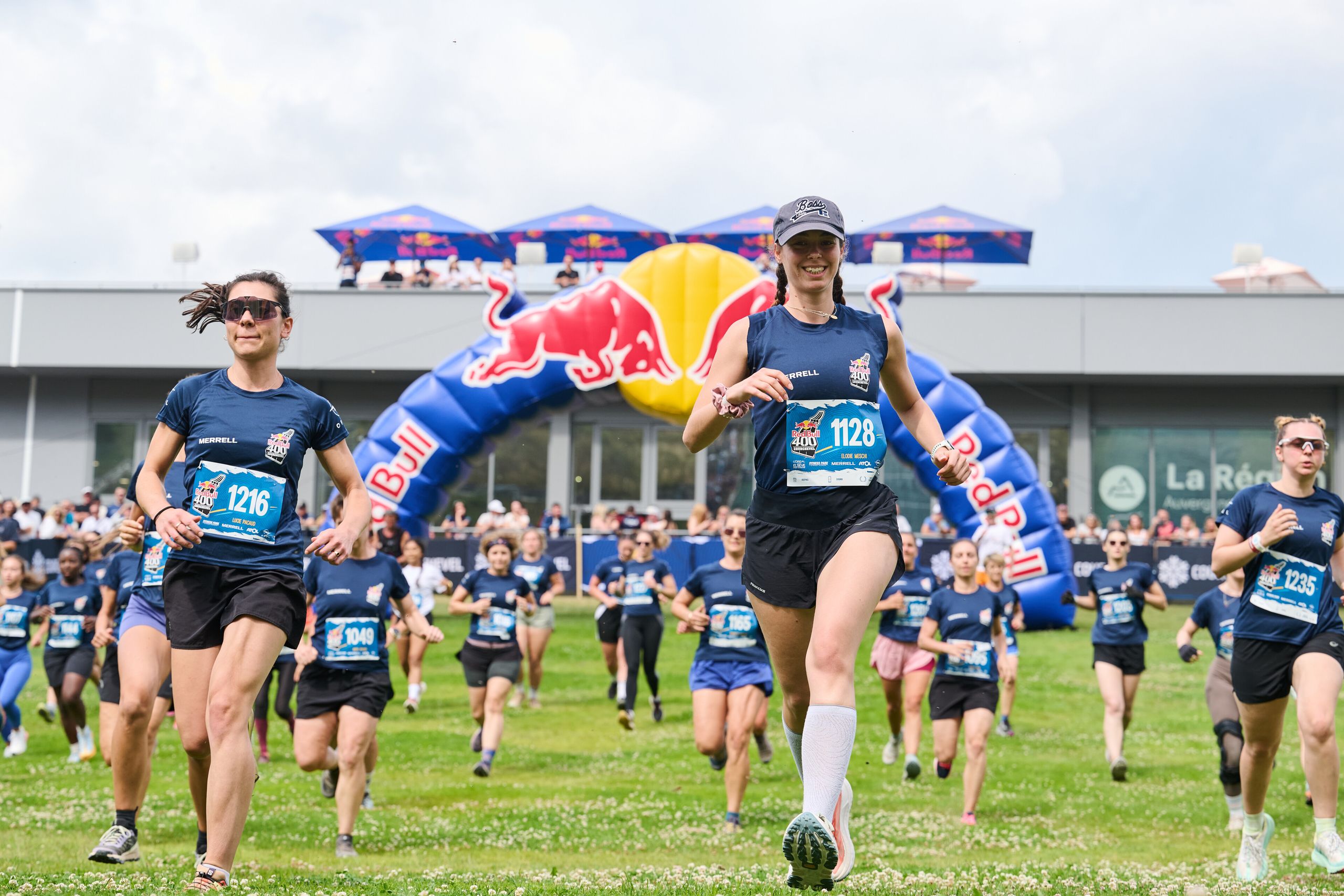 Départ d'une vague de coureuses sous l'arche Red Bull